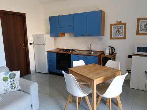 a kitchen with blue cabinets and a wooden table and chairs at Salina in Trappeto