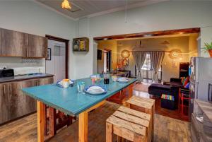 a kitchen and living room with a blue table and chairs at Harbour House Mossel Bay - near sea & activities in Mossel Bay