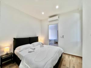 a bedroom with a large bed with white sheets at Comfortable 1-Bedroom Central Menton in Menton