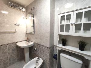 a bathroom with a sink and a toilet and a mirror at 009 Bungalow Torrelamata in La Mata +18 photos
