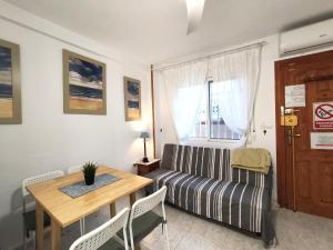 a living room with a table and a couch at 009 Bungalow Torrelamata in La Mata