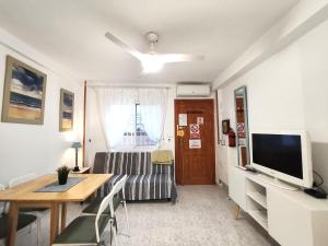 a living room with a table and a television at 009 Bungalow Torrelamata in La Mata