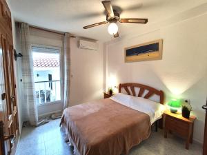 a bedroom with a bed and a ceiling fan at 009 Bungalow Torrelamata in La Mata