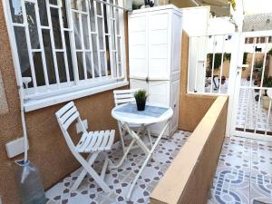 a patio with a table and chairs on a balcony at 009 Bungalow Torrelamata in La Mata