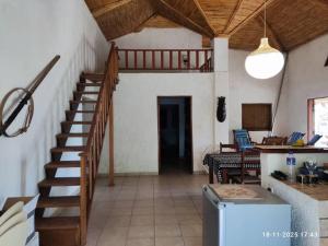 a hallway with a staircase in a house with a table at Baobab Beach Villa in Abémé