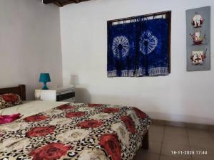 a bedroom with a bed and a curtain on the wall at Baobab Beach Villa in Abémé +26 photos