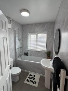 a bathroom with a tub and a toilet and a sink at Parkfield House in Smethwick +14 photos