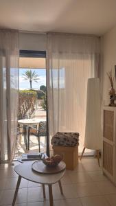 a living room with a table and a view of the ocean at Séjour bord de mer Résidence avec piscine Cannes in Cannes