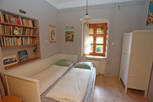 a bed in a room with a book shelf at Green Tree Apartment in Pécs
