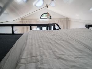 a white bed in a room with a table at Kelluva Jokimaja in Turenki