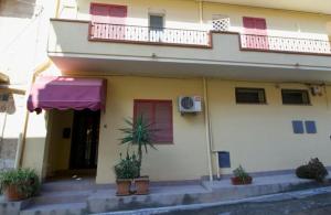 a building with potted plants in front of it at Salina in Trappeto