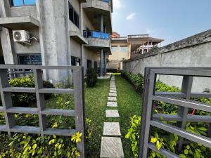 a garden with a gate and a walkway next to a building at A quiet corner in Cotonou in Cotonou +3 photos
