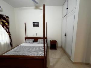a bedroom with a bed with a wooden frame at A quiet corner in Cotonou in Cotonou