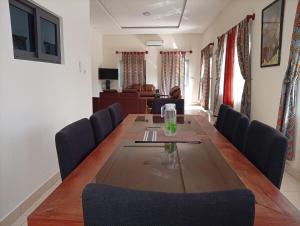 a dining room with a long table and blue chairs at A quiet corner in Cotonou in Cotonou