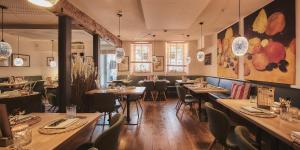 a restaurant with tables and chairs in a room at Weinforum Franken Hotel & Restaurant in Eibelstadt