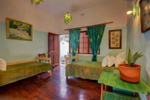 a bedroom with two beds and a table and a window at Harbour House Mossel Bay - near sea & activities in Mossel Bay