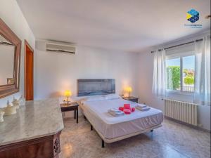 a bedroom with a bed and a table with two lamps at Can Moragues and Martorell in Badia Blava +41 photos