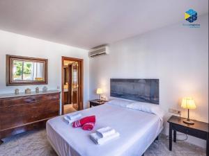 a bedroom with a large white bed with red pillows at Can Moragues and Martorell in Badia Blava