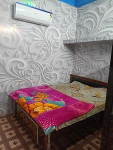 a bed with a colorful blanket on it in a room at Oyo Royal Hotel & Janmasha in Rewa