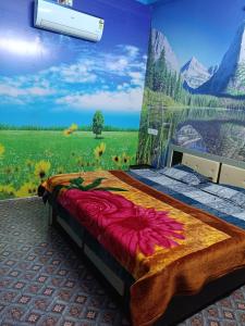 a bedroom with a mural of a field of flowers at Oyo Royal Hotel & Janmasha in Rewa