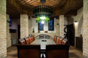 a conference room with a table and chairs and a chandelier at Zlaten Rozhen Family Hotel- Monument of Cultural Significance in Rozhen