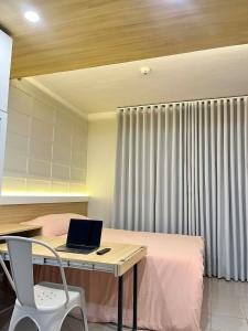 a bedroom with a desk with a laptop on a bed at Suite Talie Cebu Cozy Modern Stay with Pool & Netflix in Lapu Lapu City +9 photos