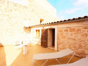 a patio with white chairs and a building at Ca'n Climent in Llucmajor