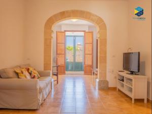 a living room with a couch and a tv at Ca sa comare in Llucmajor