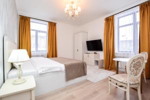 a white bedroom with a bed and a table and chair at Hotel Astoria, в самом центре города in Astana +43 photos