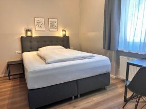 a bedroom with a bed with a headboard and a desk at Hotel Villa Solln - free parking in Munich +51 photos
