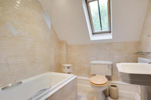 a bathroom with a tub and a toilet and a sink at 3 Bed in Thursford oc-2370 in Thursford +12 photos