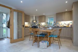 a kitchen with a table and chairs in it at Bamford Barn in Ottery Saint Mary