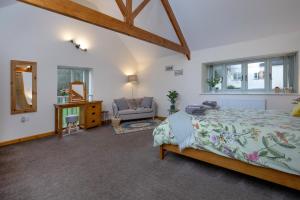 a bedroom with a bed and a chair in a room at Bamford Barn in Ottery Saint Mary