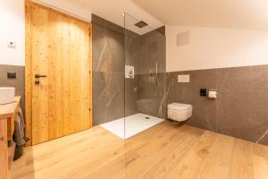 a bathroom with a toilet and a glass shower at Gasthof Videgg in Schenna +57 photos