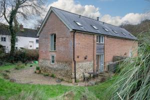 an old brick house with a lot of windows at Bamford Barn in Ottery Saint Mary