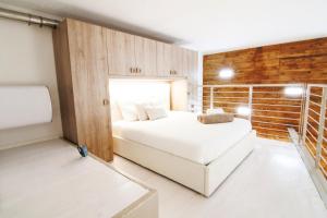 una camera con un letto bianco e un muro di mattoni di Alessia's Flat - Portello a Milano