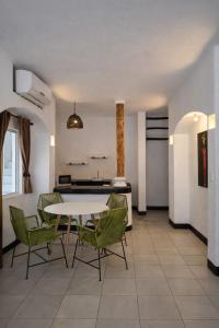 a dining room with a table and green chairs at Hotel Villa Capricho in Ciudad Madero