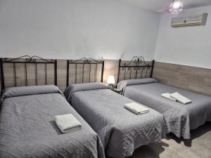 two beds with towels on them in a room at Pensión Javier in Seville