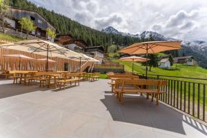 a group of tables and umbrellas on a balcony at Gasthof Videgg in Schenna