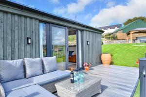 a patio with a couch and a table on a deck at 2 Bed in Abererch oc-glwysf in Abererch