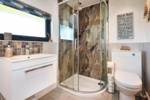 a bathroom with a shower and a toilet and a sink at 2 Bed in Abererch oc-glwysf in Abererch +17 photos