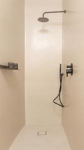 a white wall with a shower with a light on it at DOMUS 1435 - Iconic Suites in Centro in Mantova +40 photos