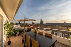 a balcony with a table and chairs on a roof at Bright Beachside Flat with Terrace by HostWise in Matosinhos