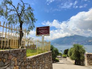 a sign for a restaurant called coastal living on a fence at Residence Casa Maria in Assenza di Brenzone
