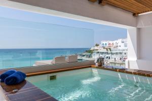ein Schwimmbad mit Blick auf ein Gebäude in der Unterkunft Mykonos Kosmoplaz Beach Resort Hotel in Platis Gialos