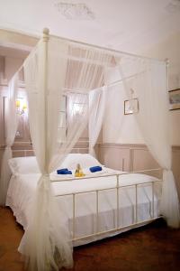 フィレンツェにあるOltrarno Florence Apartmentのベッドルーム(天蓋付き白いベッド1台付)