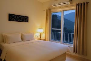 a bedroom with a bed and a large window at Pennylane Hotel - Aesthetic Rooms with pottery studio, artshala, garden cafe, free airport pickup for 7 or more nights bookings in Rishīkesh