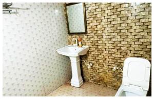 a bathroom with a sink and a toilet and a mirror at Hotel Indra Palace Jaunpur in Jaunpur