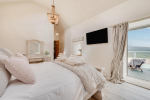 a white bedroom with a large bed and a window at 3 Bed in Trawsfynydd oc-wag718 in Trawsfynydd