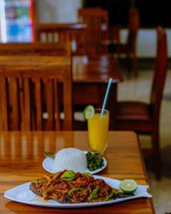 a plate of food with rice and a drink on a table at Dream Kilimanjaro Complex Hotel in Msaranga